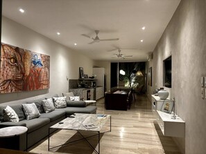 A modern living room with a sofa, coffee table, and artwork on the wall.