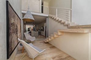 Een modern interieur met een trap, een eethoek en een hanglamp.