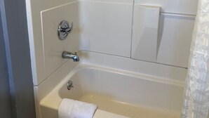 A bathroom with a bathtub, a shower, and a toilet. - Driftwood Motel - Colton (Colton)