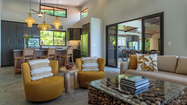 A modern living room with a sofa, armchairs, and a glass coffee table.