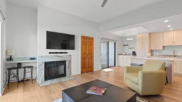 A modern living room with a fireplace, a TV mounted on the wall, and a comfortable seating area.