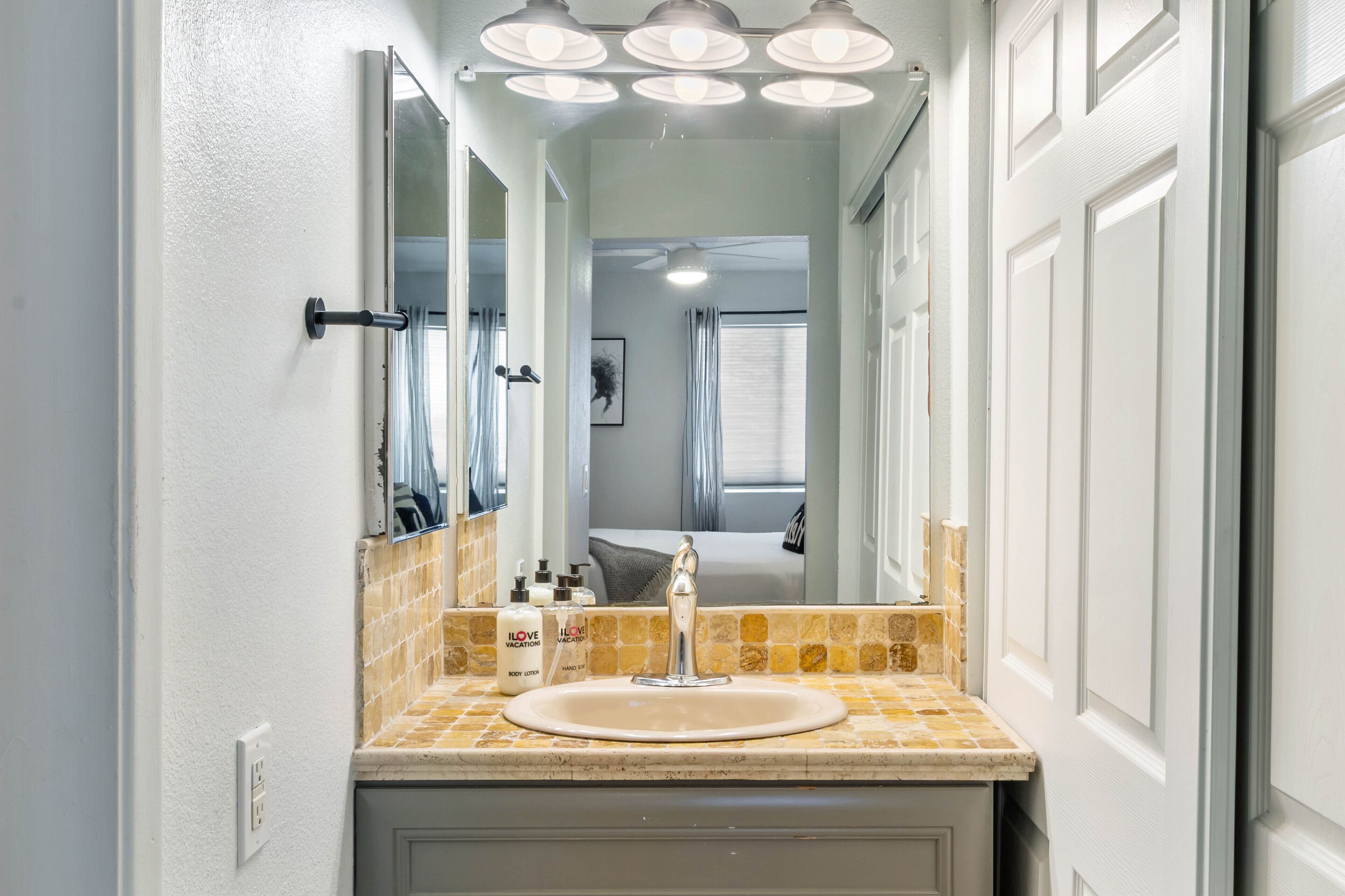 Une salle de bain avec un lavabo, un miroir et un meuble-lavabo.