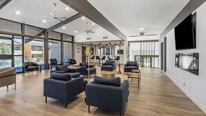 A spacious living area with modern furniture, large windows, and a flat-screen TV mounted on the wall. - Woodland Springs with Community Pool, Hot Tub, Tennis, Sauna & Fitness Center C209 (Scottsdale)