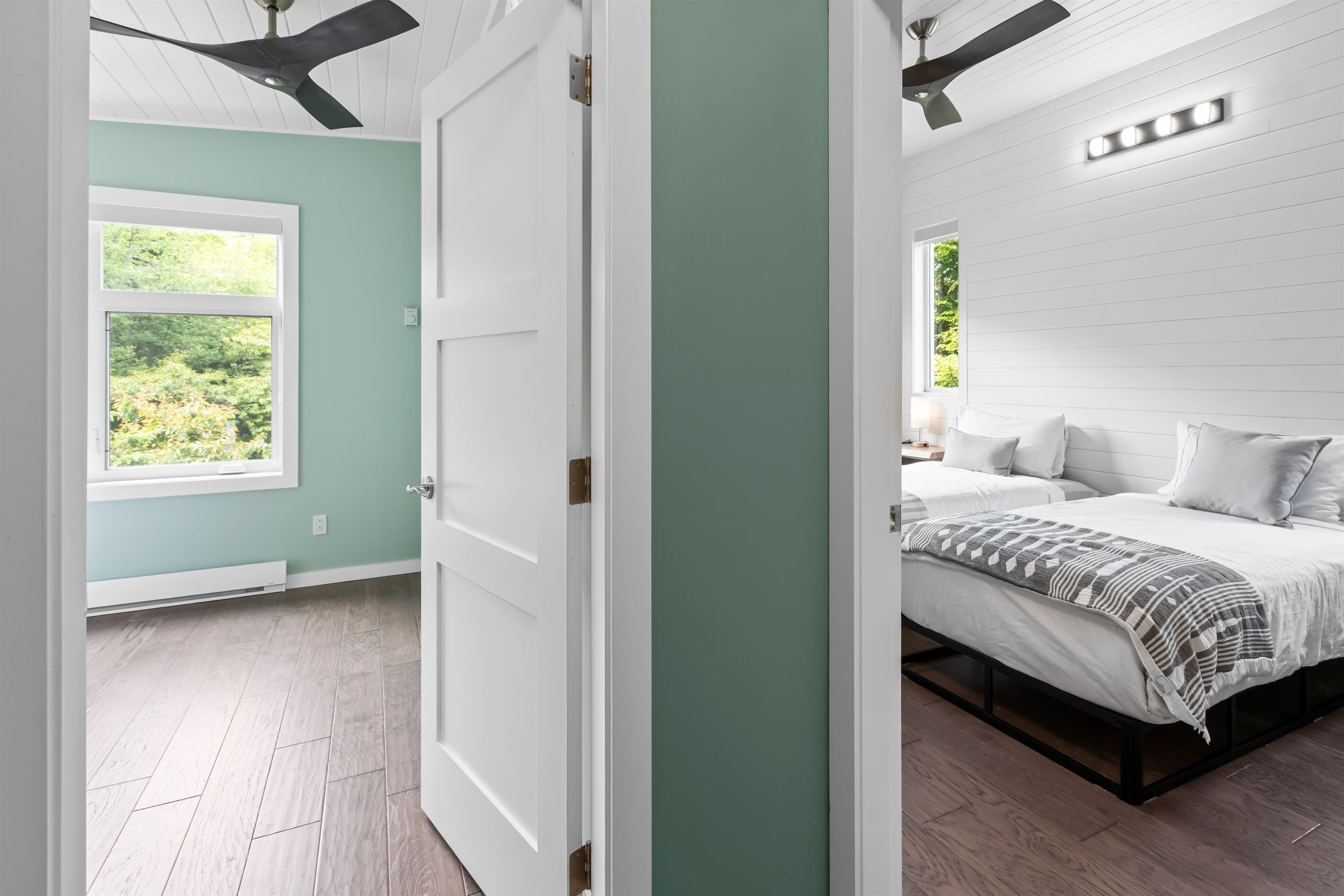 Un dormitorio con cama, ventana y ventilador de techo.