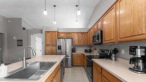 A modern kitchen with wooden cabinets, stainless steel appliances, and pendant lighting. - Red Mountain Retreat - 4B/2B with Private Pool for your Arizona Getaway (Mesa)