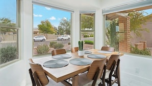 A dining area with a large table, six chairs, and a cactus centerpiece.