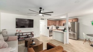A modern apartment with a living room, kitchen, and dining area.