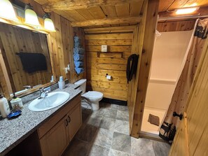 Bañera con ducha, jabón, shampoo, papel higiénico