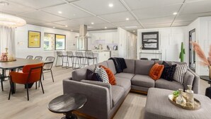 A modern living room with a sectional sofa, dining table, and chairs.