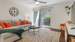 Una sala de estar moderna con sofá, mesa de centro y ventilador de techo.