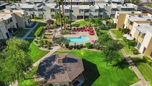 Zona residencial con piscina, una casa y edificios de apartamentos.