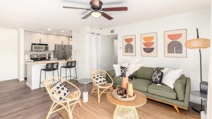 Un appartement moderne comprenant une cuisine, un coin repas et un salon.