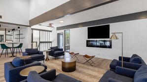 Un espace de vie moderne comprenant des canapés, une table basse et un téléviseur à écran plat fixé au mur.