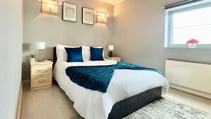 A neatly arranged bedroom with a bed, bedside tables, and wall-mounted lights. - Canary Wharf Gem - Prvt Parking - Fast WiFi - O2 & Excel - Sleeps 4 (London)