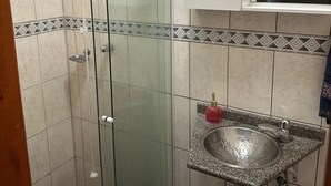A bathroom with a glass shower enclosure, a granite sink, and a white cabinet above the sink. - The most complete and in the best location in Florianópolis-SC. (florianópolis)