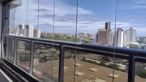 A cityscape view from a balcony with high-rise buildings in the background. - Dolphins Tech (Salvador)
