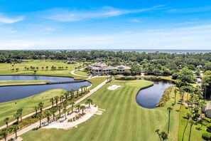 A golf course with a clubhouse, water hazards, and well-maintained lawns.