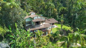 A two-story house with a tiled roof, surrounded by dense tropical vegetation. - Felix Ocean View, Ubatuba, Sao Paulo, Brazil. (Ubatuba)