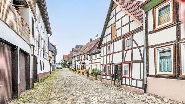 Eine Kopfsteinpflasterstraße gesäumt von traditionellen Fachwerkhäusern.