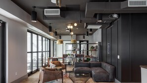Een modern interieur met een groot raam, een bank, een eettafel en hanglampen.
