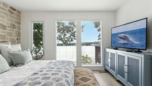 A bedroom with a bed, a television, a wardrobe, and a window with blinds. - Hot Tub, Main Channel Views, Great Outdoor Spaces, Blackstone (Sunrise Beach)