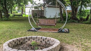 A circular swing set with a bench in the center, surrounded by a brick fire pit. - Families, Fishermen & Hunters. Pleasant 3-bedroom house and dock ready for you! (Eufaula)