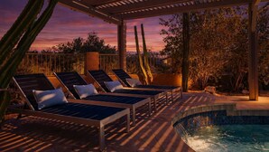 A poolside area with lounge chairs and a pool.