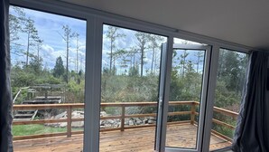 Et værelse med store skydedøre, der fører ud til en terrasse.