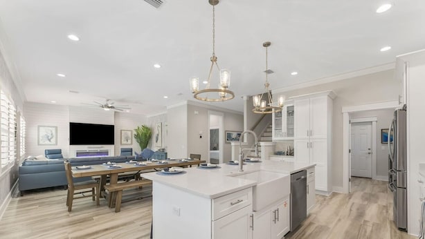 Una cocina moderna con armarios blancos, una isla central y electrodomésticos de acero inoxidable.