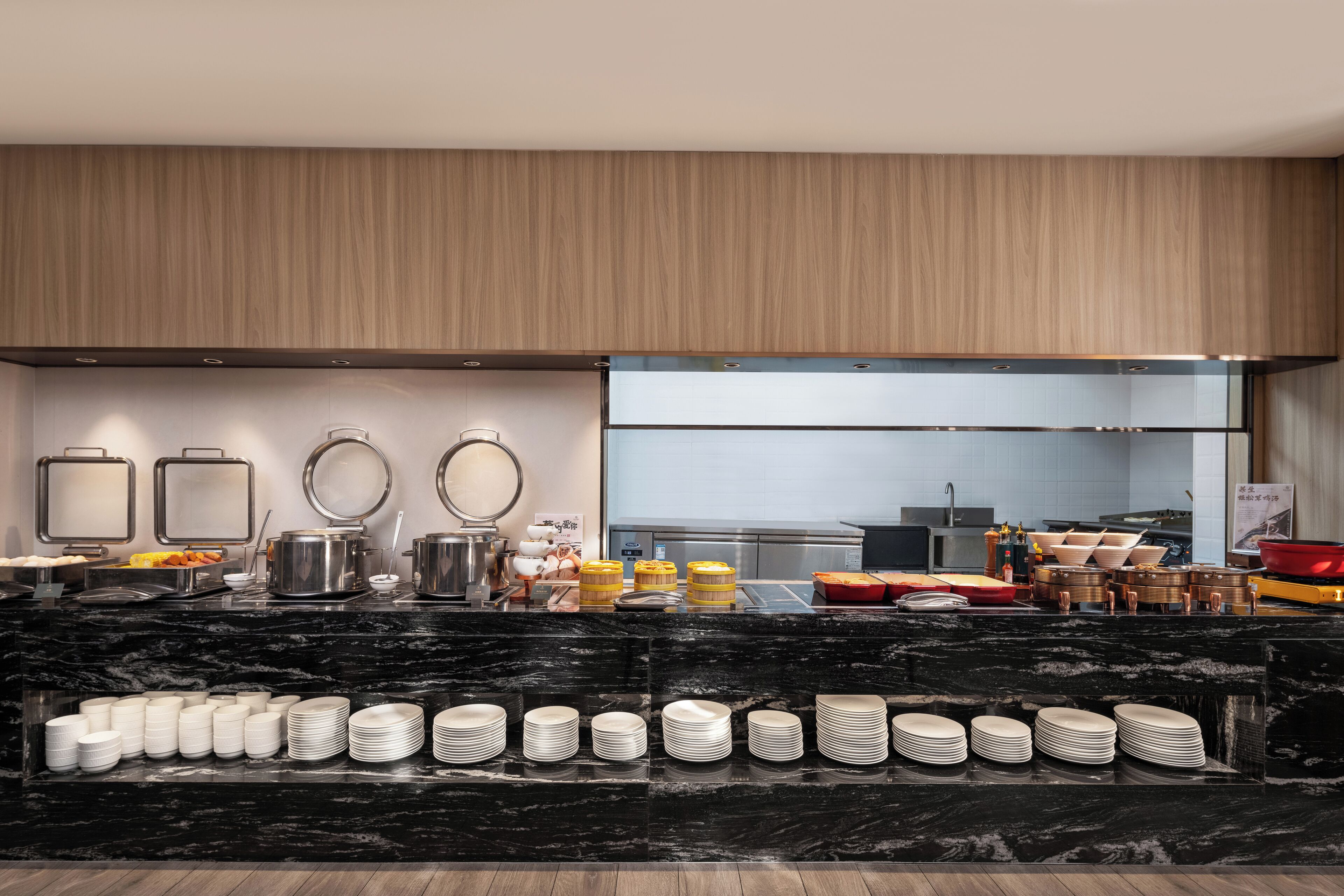 A modern kitchen with a marble countertop, stainless steel appliances, and neatly arranged kitchenware.