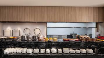 A modern kitchen with a marble countertop, stainless steel appliances, and neatly arranged kitchenware.