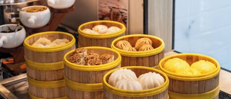 A display of various steamed buns in bamboo steamers, arranged on a counter.