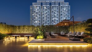 Una terraza en la azotea con mobiliario exterior y vistas a un edificio alto.
