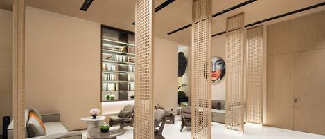 A modern interior with a sofa, chairs, a coffee table, and a bookshelf.