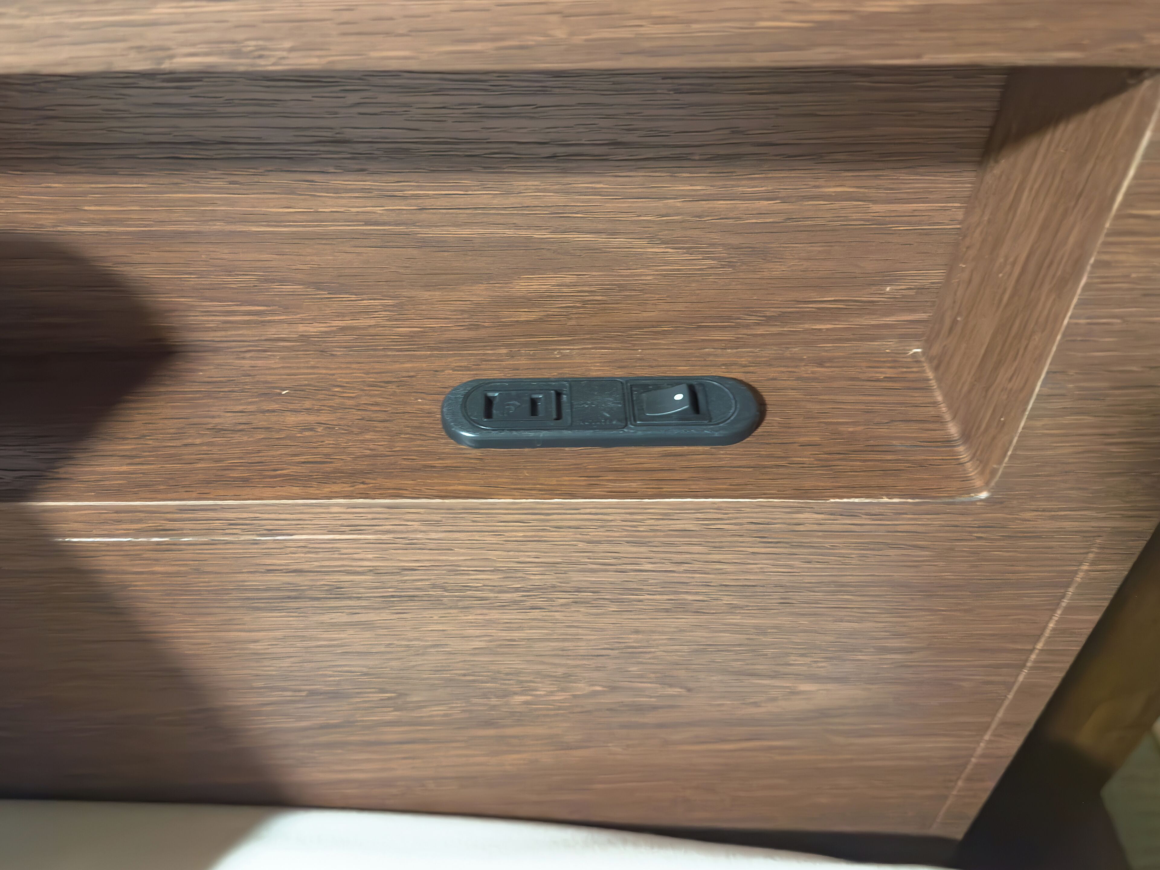 Eine Holzkassette mit einer schwarzen Steckdose.