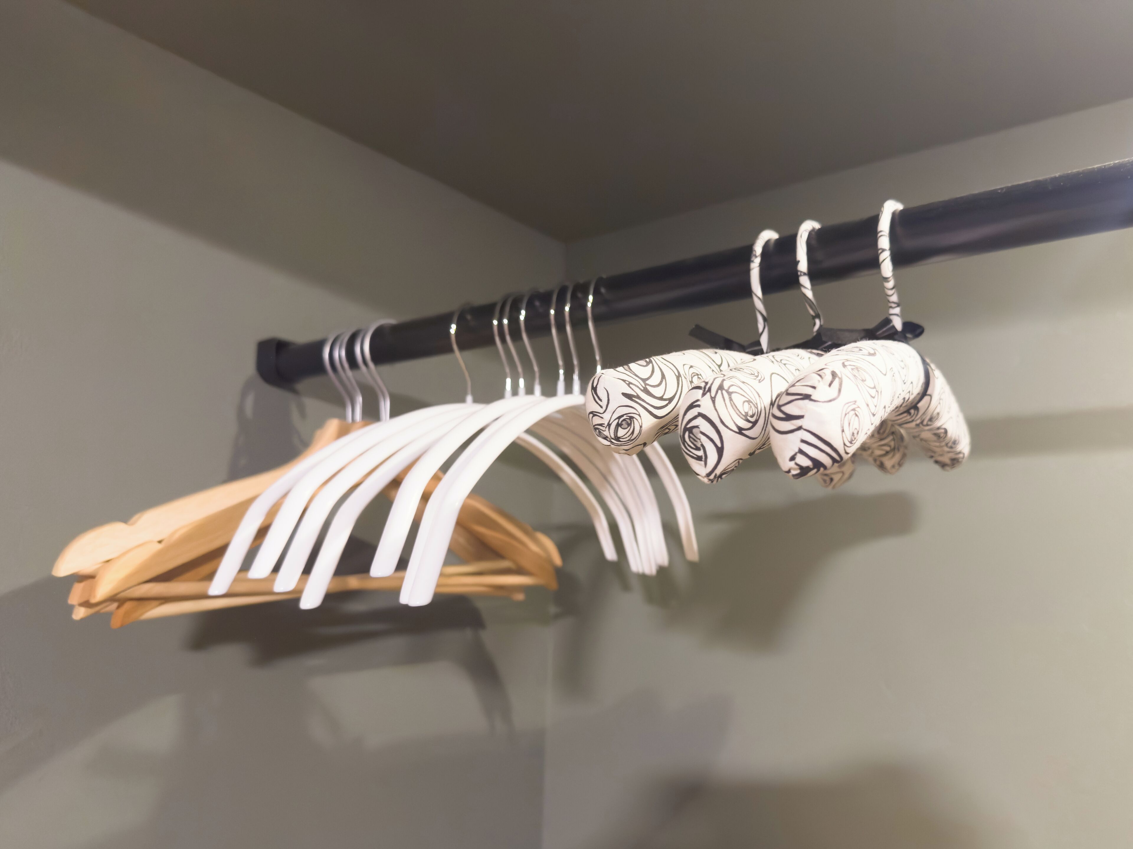 Un perchero con varios perchas, incluyendo perchas de madera y con diseños.
