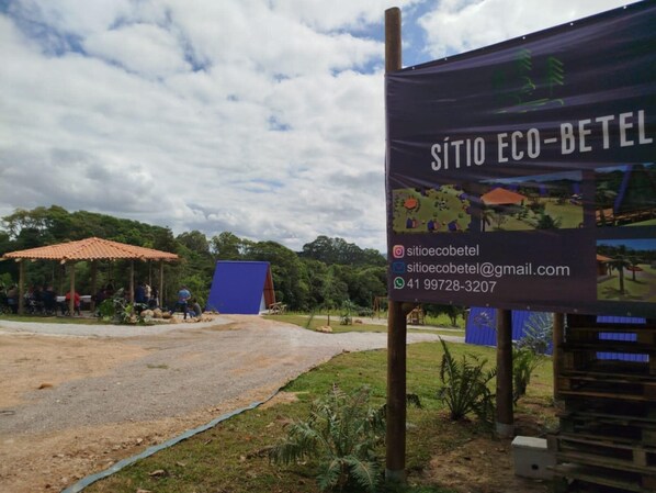 A signboard for Sítio Eco-Betel with contact information and a map illustration.