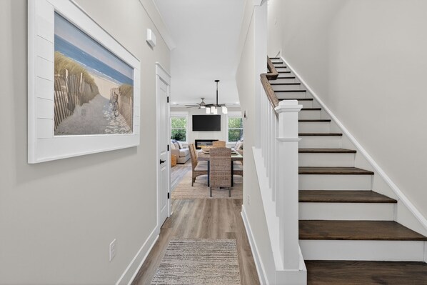A hallway leading to a dining area with a staircase.