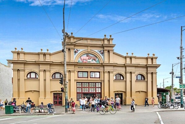 A historic building with a large arched entrance and a sign reading "Queen Victoria Market".