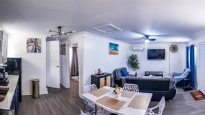 Un salon moderne comprenant un coin repas, une cuisine et une salle de bain.