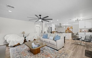A modern living room with a white sofa, a coffee table, and a patterned rug. - Stylish 4BR Pool Oasis,ASU,Spring Training! Old Town Scottsdale 10 minutes away. (Tempe)