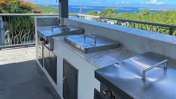 Un área de cocina al aire libre con vista al océano y un letrero que dice "BEACH".