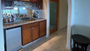 Una cocina con armarios de madera, un refrigerador empotrado y una encimera con diversos objetos.