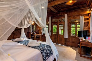 Una habitación con una cama, un escritorio y un televisor.