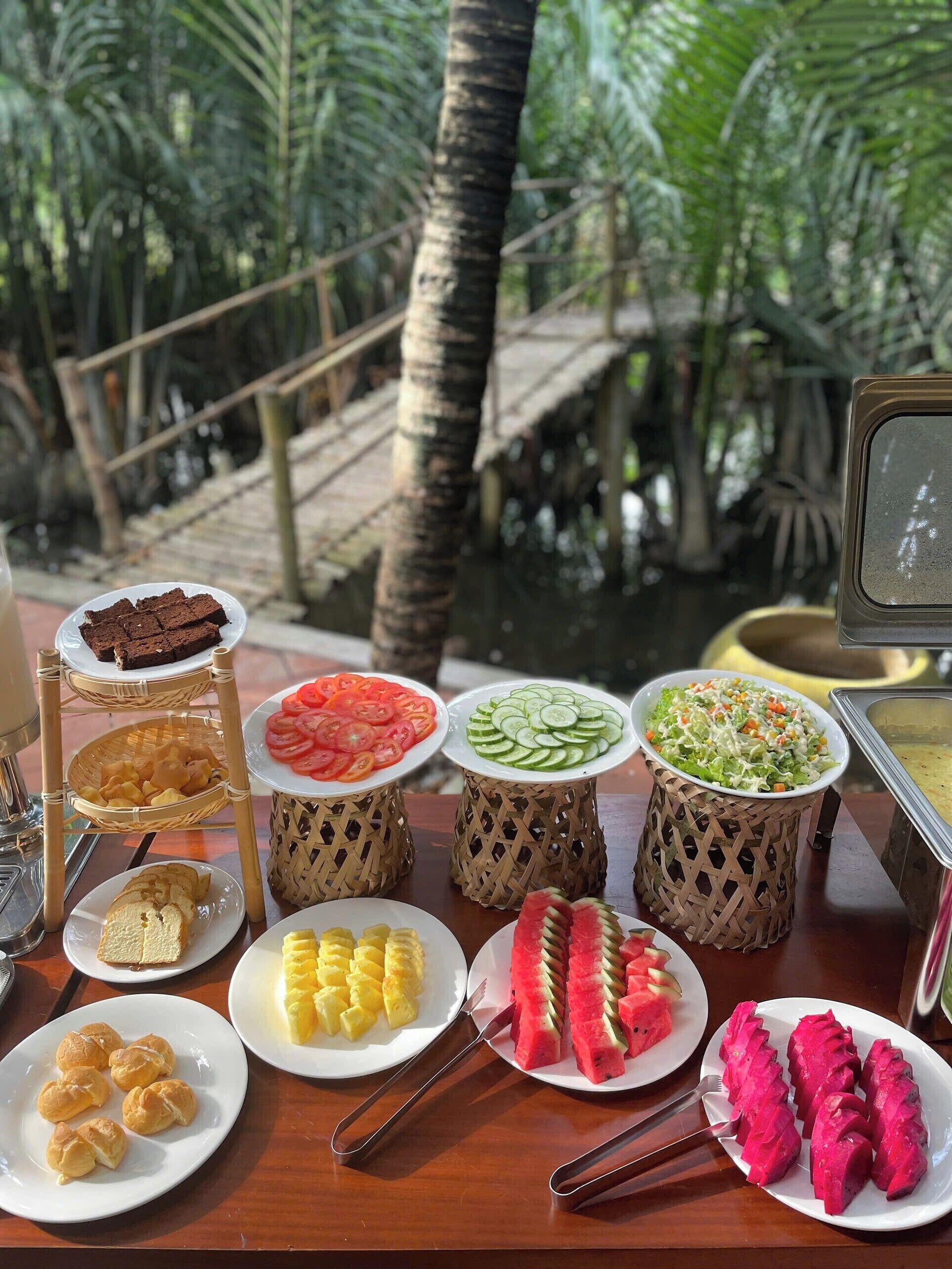 A buffet table with various food items including bread, fruit, and salads.
