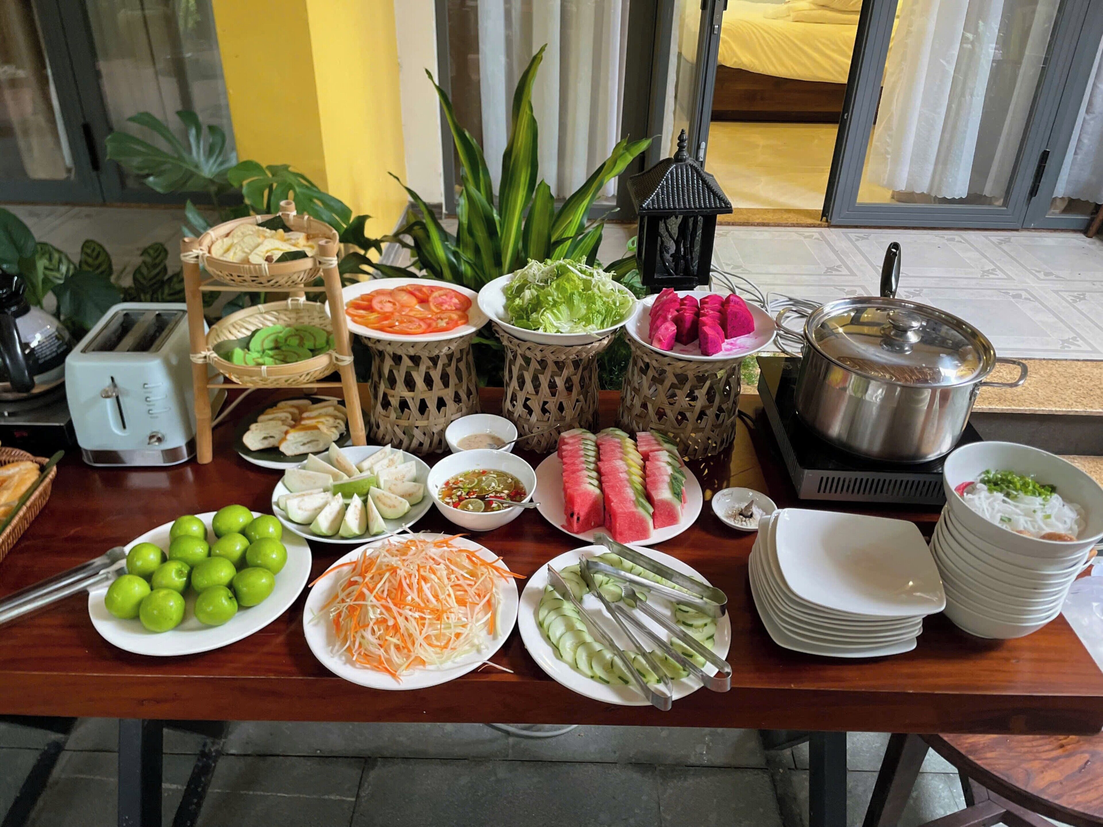 Une table de buffet avec divers plats, un grille-pain et une casserole sur une cuisinière.