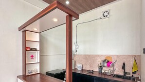 A reception desk with a wooden frame, a white counter, and a shelf with a first aid kit. - Skypiea dieng (Dieng Kulon)