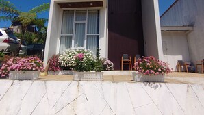 A two-story building with a balcony, large windows, and a flat roof. - Skypiea dieng (Dieng Kulon)