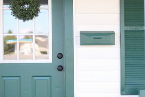 A teal door with a window and a mailbox on the wall. - Cottage In Downtown Georgetown Within Walking Distance Of Shops and Restaurants (Georgetown)