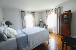 A bedroom with a bed, bedside table, lamp, and a wooden cabinet. - Cottage In Downtown Georgetown Within Walking Distance Of Shops and Restaurants (Georgetown)